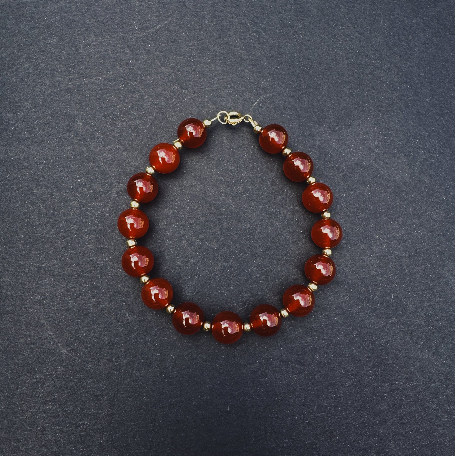 Bracelet with red beads on a dark gray background