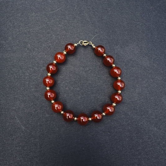 Bracelet with red beads on a dark gray background