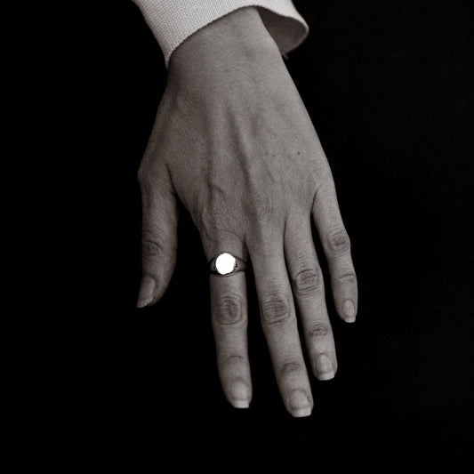 Hand wearing a ring on a black background