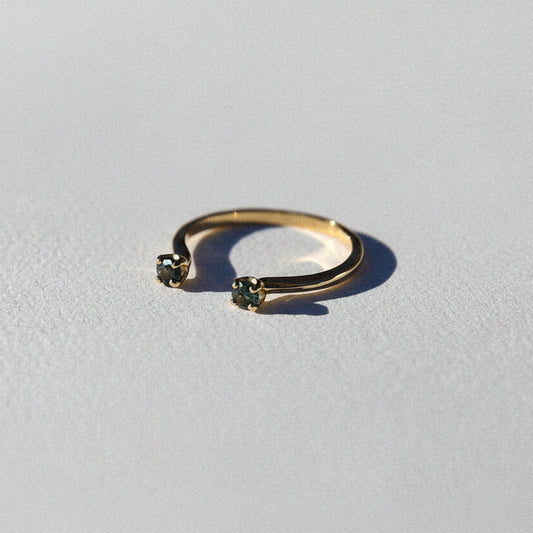 Gold ring with small gemstones on a light gray background