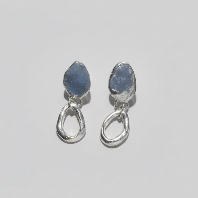 Pair of silver earrings on a studio backdrop
