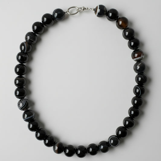 Black beaded necklace on a white background