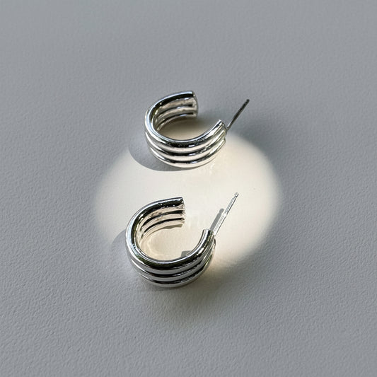 Silver hoop earrings on a light gray background
