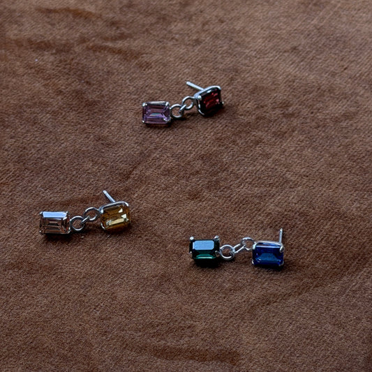 Three pairs of earrings on a brown surface