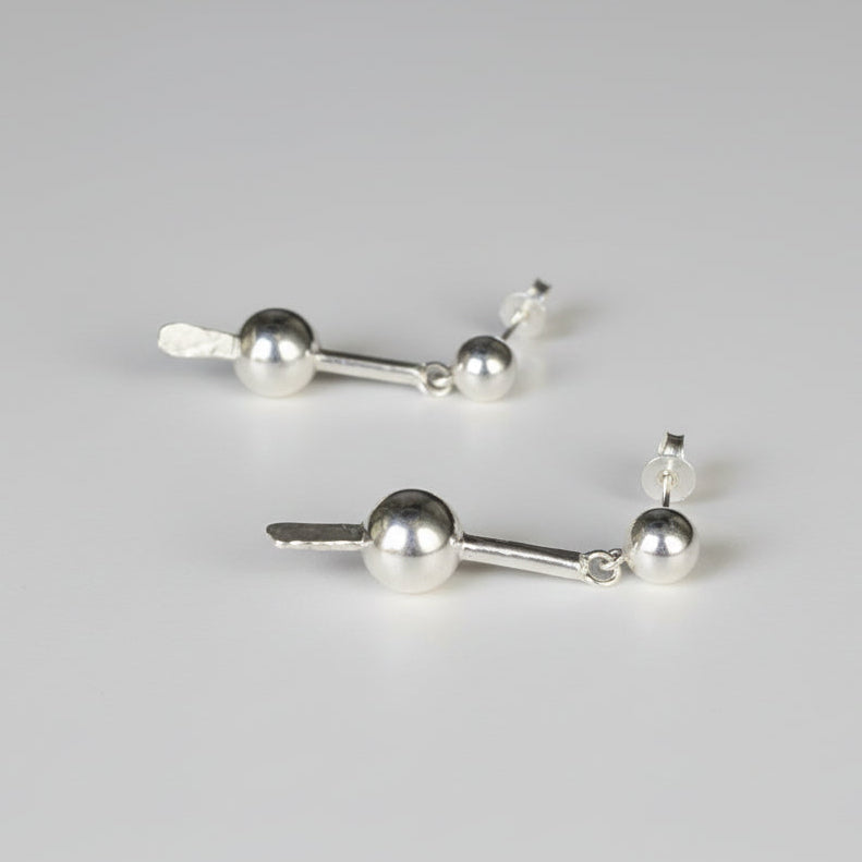 Pair of silver earrings on a studio background