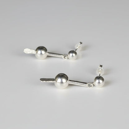 Pair of silver earrings on a studio background
