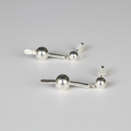 Pair of silver earrings on a studio background