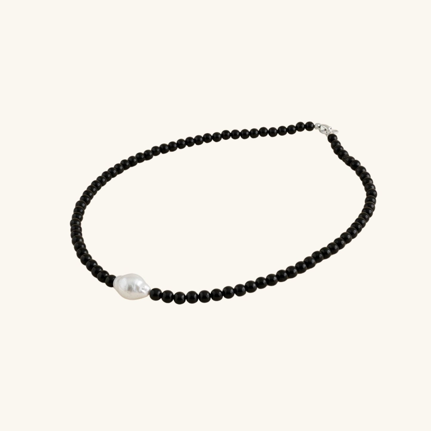 Necklace with black beads and a pearl on a white background