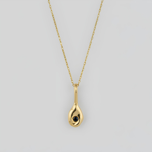 Gold teardrop pendant necklace on a light gray background