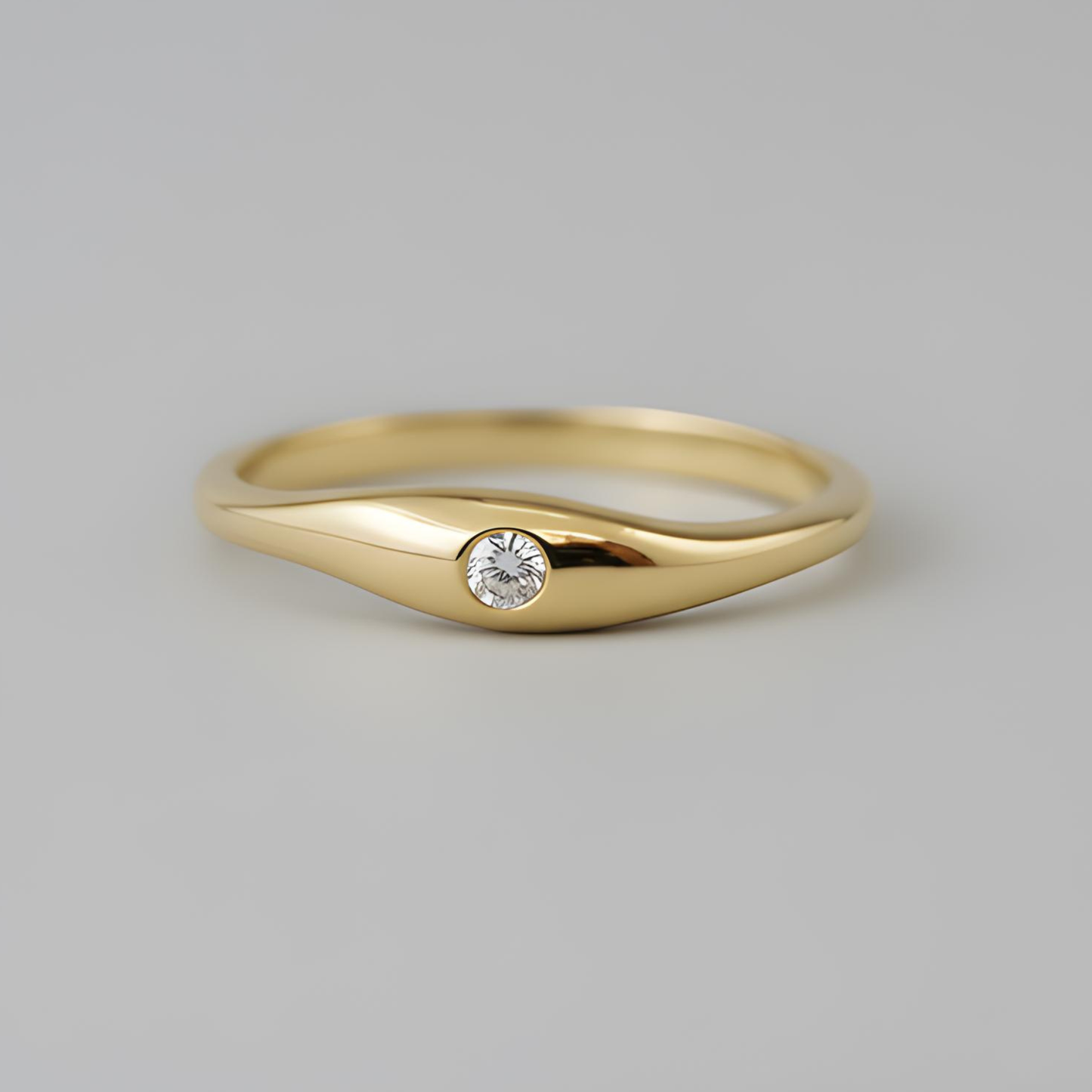 Gold ring with a diamond on a gray background