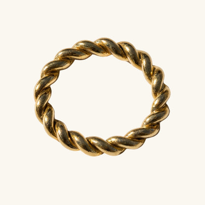 Gold twisted ring on a white background