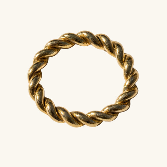 Gold twisted ring on a white background