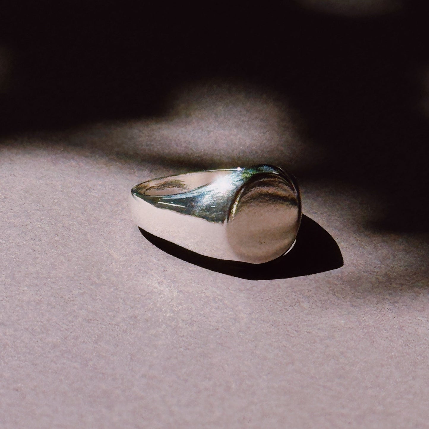 silver ring on dark background in the sun