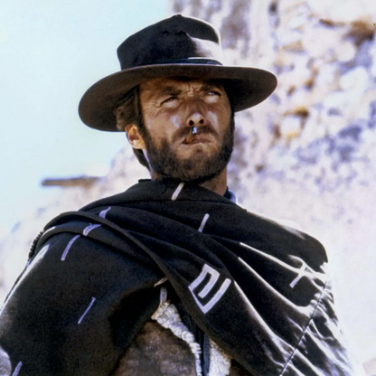 Clint Eastwood in a cowboy hat and black scarf against a rocky background