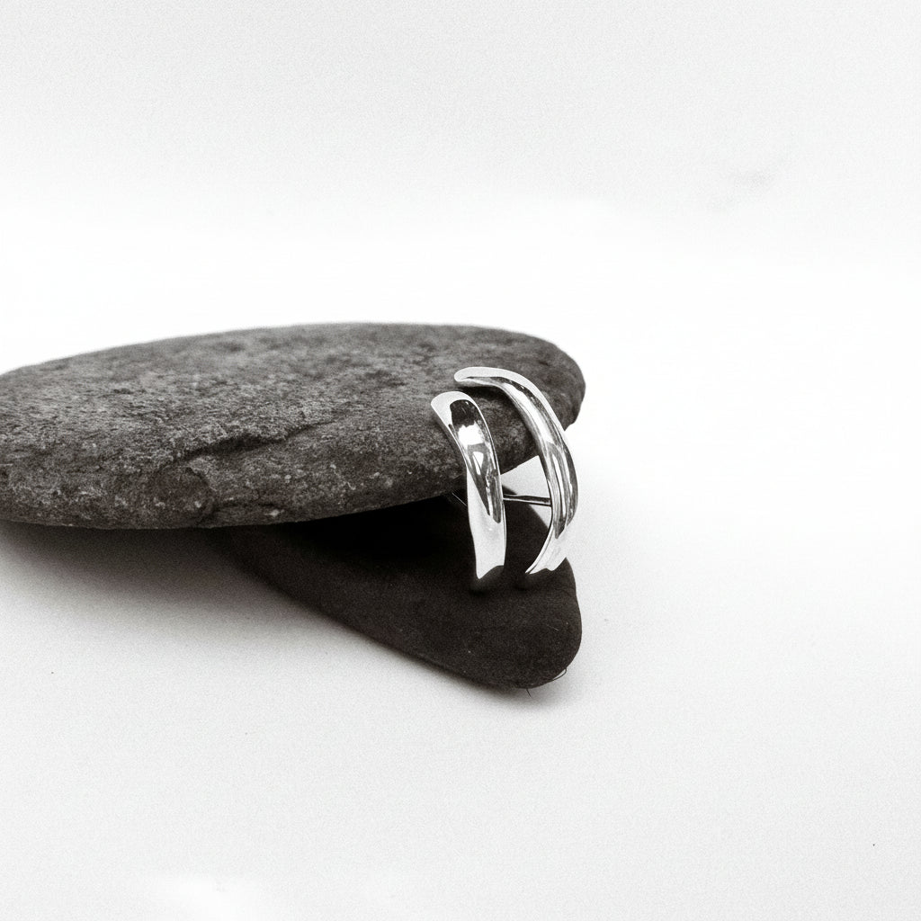 Silver earrings on a gray stone against a white background