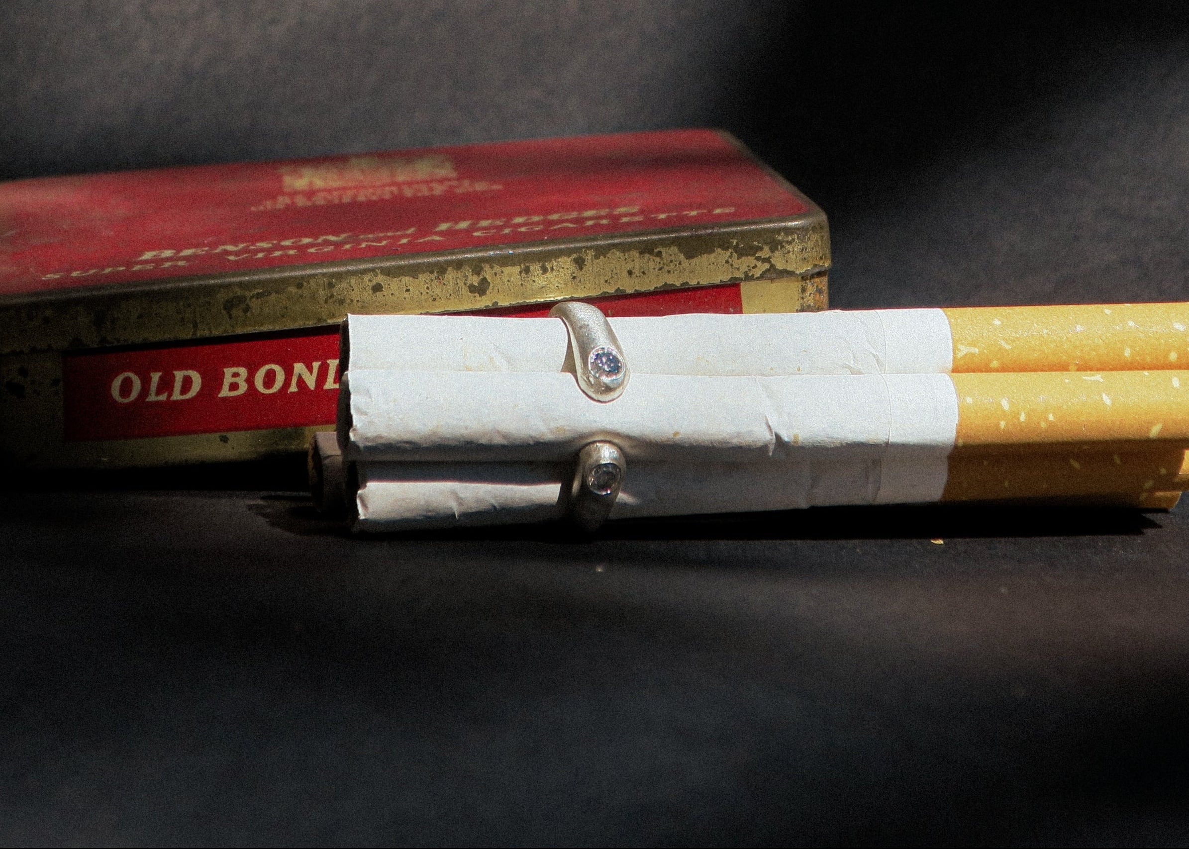 Two cylindrical objects on a dark surface with a red box labeled 'Old Bond' in the background.