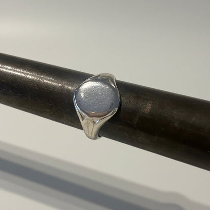 Silver signet ring on a mandrel on a studio background