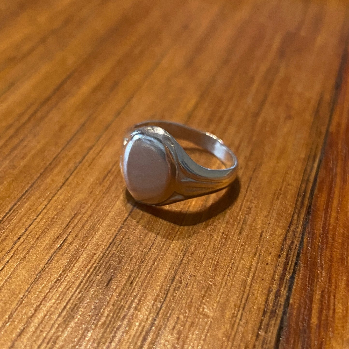 Silver ring on a wooden surface