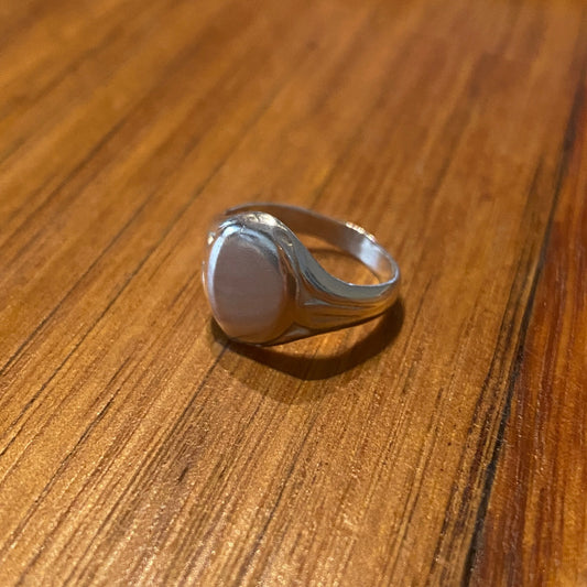Silver ring on a wooden surface