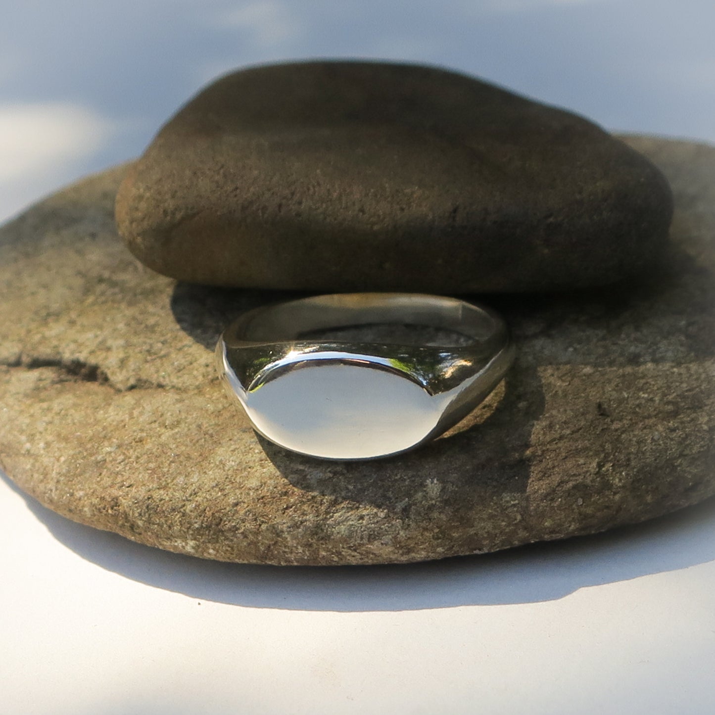 Silver ring on a stack of stones with a blurred natural background