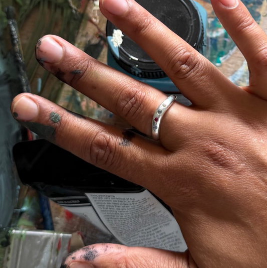 Hand with a silver ring on a blurred background