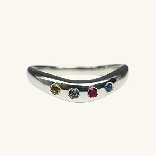Silver ring with four gemstones on a white background