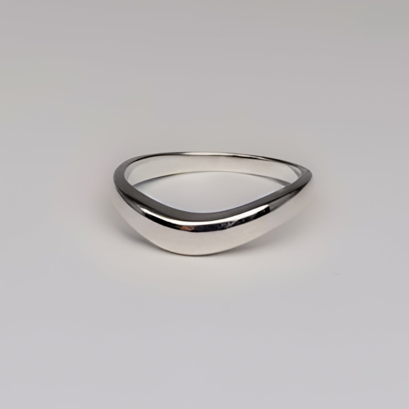Silver ring on a light gray background
