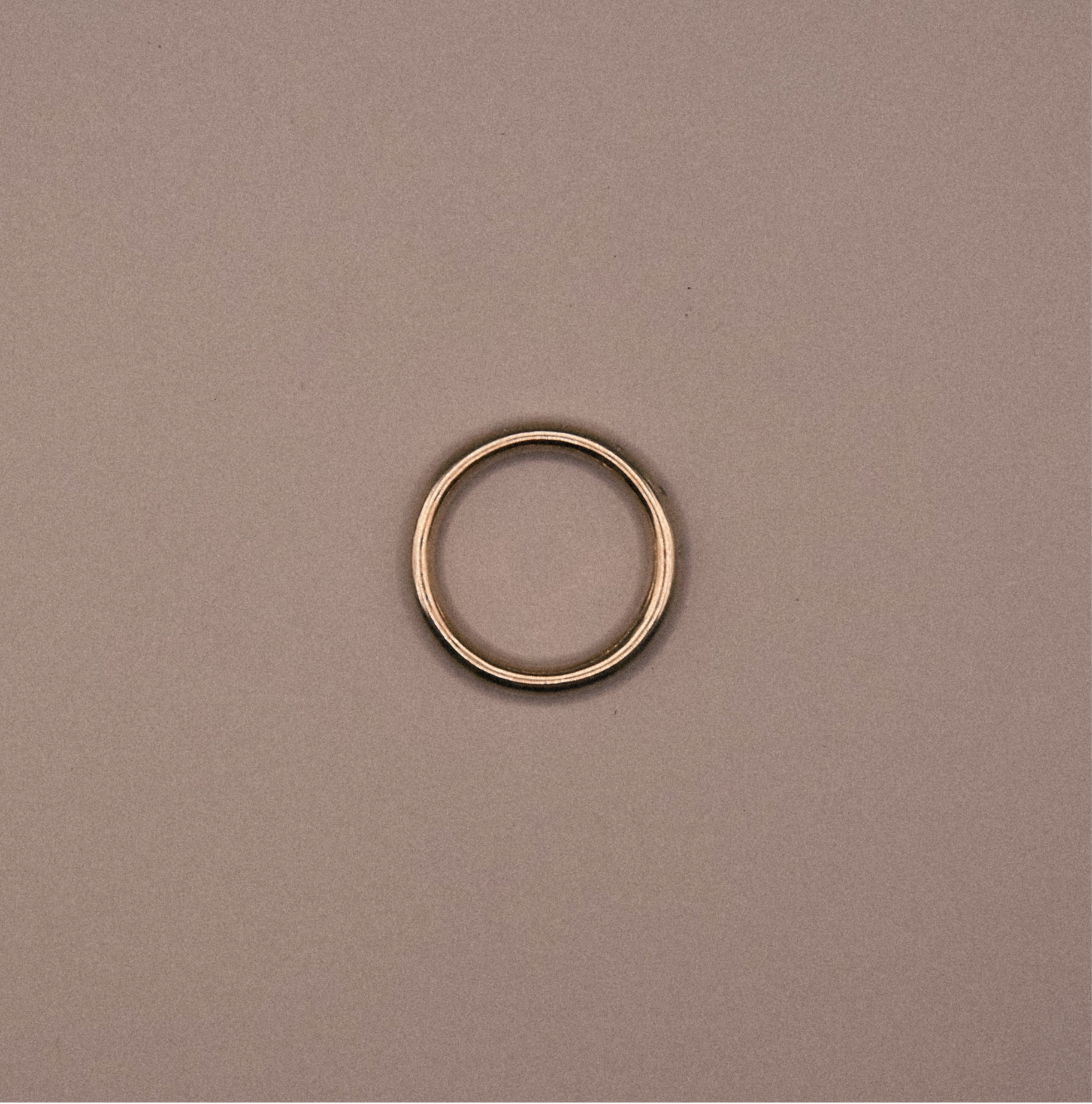 Gold ring on a beige background