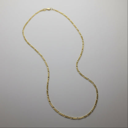 Gold chain necklace on a gray background