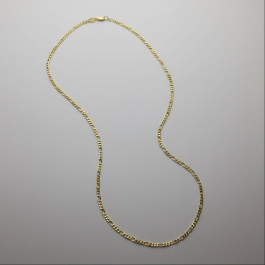 Gold chain necklace on a gray background