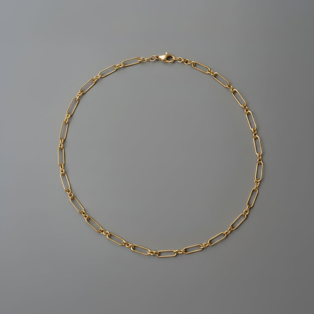Gold chain necklace on a gray background