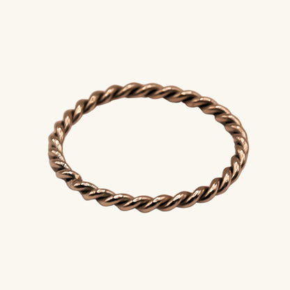 Gold twisted ring on a white background
