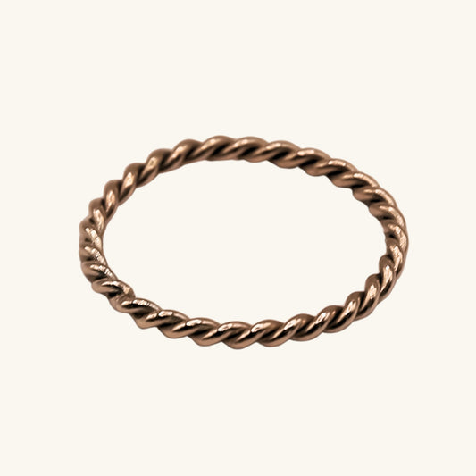 Gold twisted ring on a white background