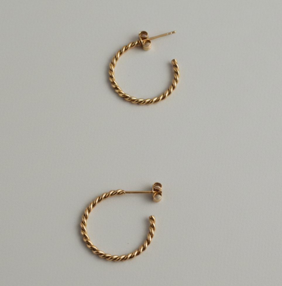 Pair of gold hoop earrings on a gray background