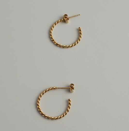 Pair of gold hoop earrings on a gray background