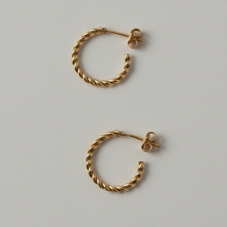 Pair of gold hoop earrings on a light gray background