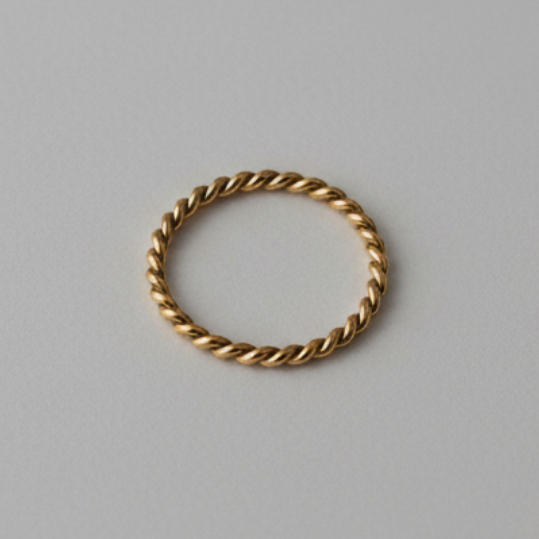 Gold ring with a twisted design on a gray background
