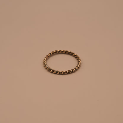 Bronze twisted ring on a beige background