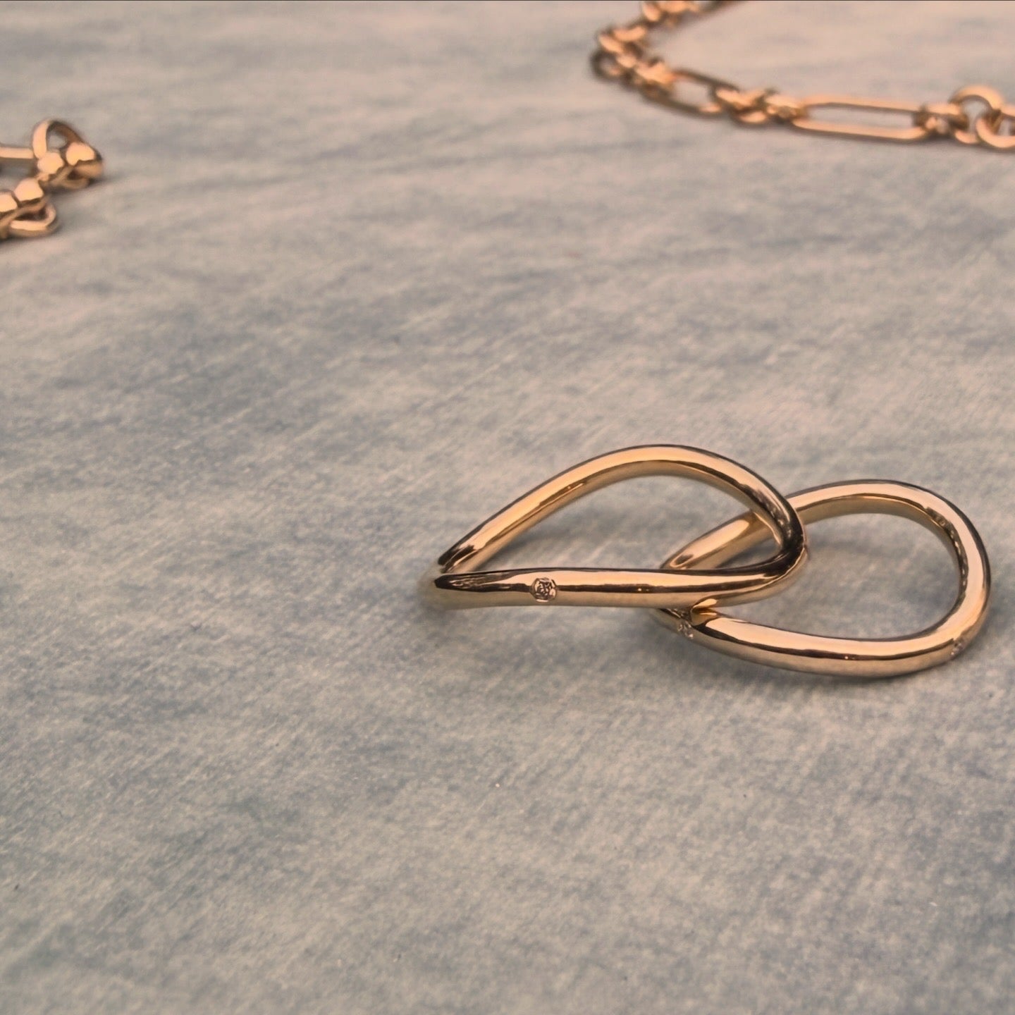 Yellow gold rings on a textured blue surface at sunset