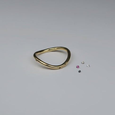 Gold ring with small gemstones on a light gray background