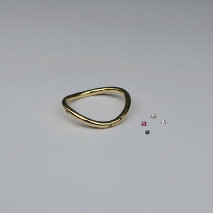 Gold ring with small gemstones on a light gray background
