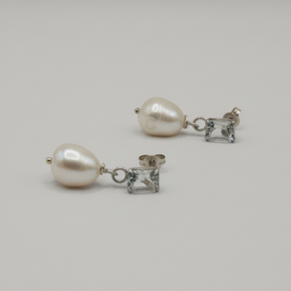 Pair of pearl earrings on a light gray background