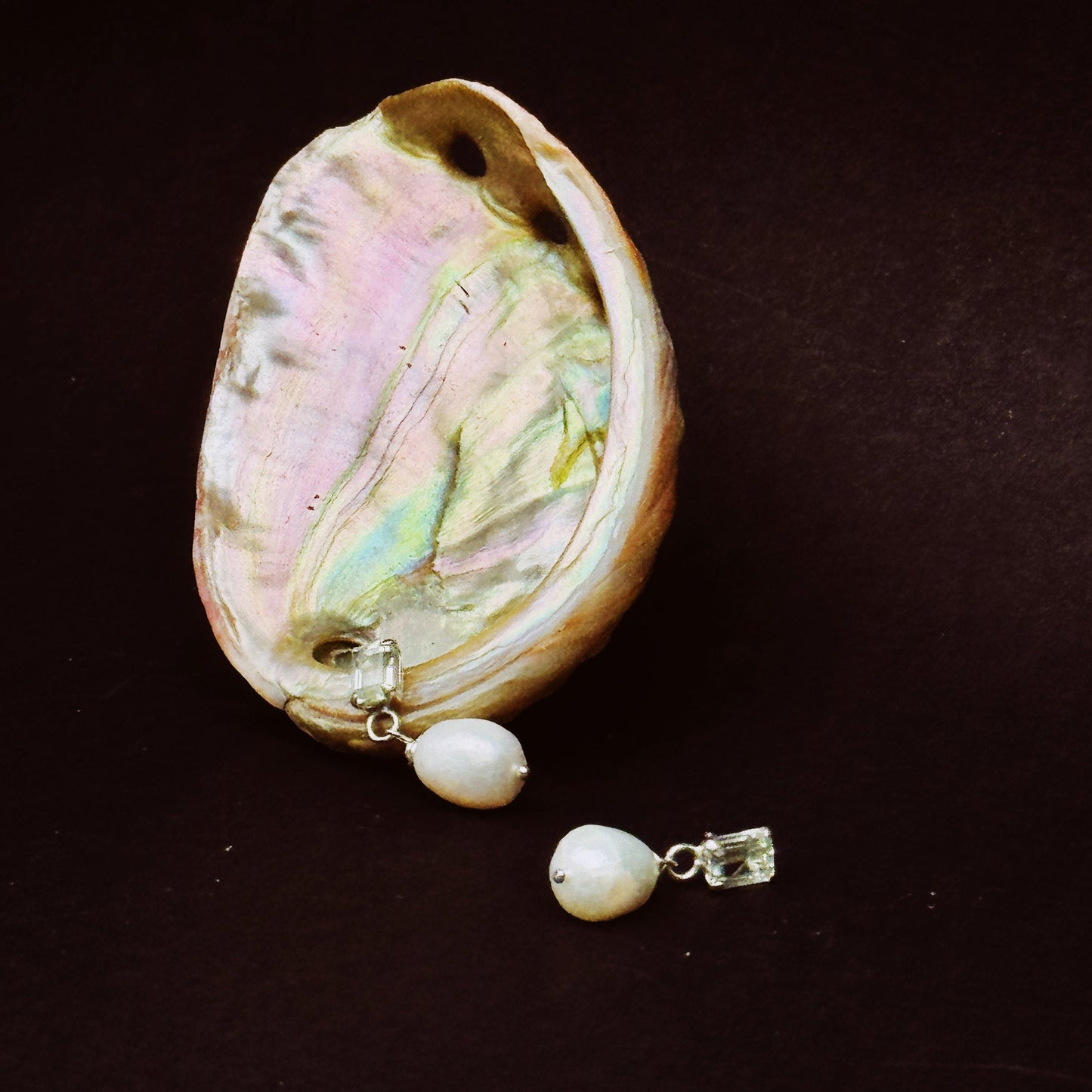 image of grace pearl studs on a black background resting on a shiny shell