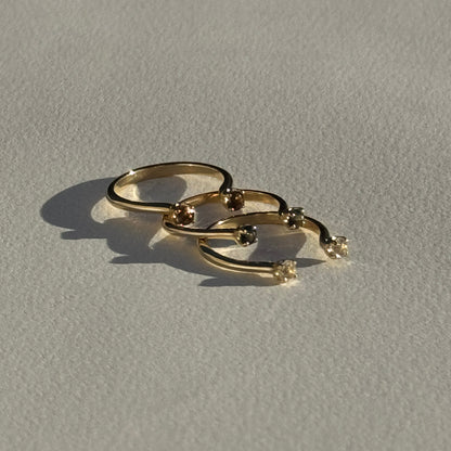 Gold ring with three interlocking loops on a light gray background