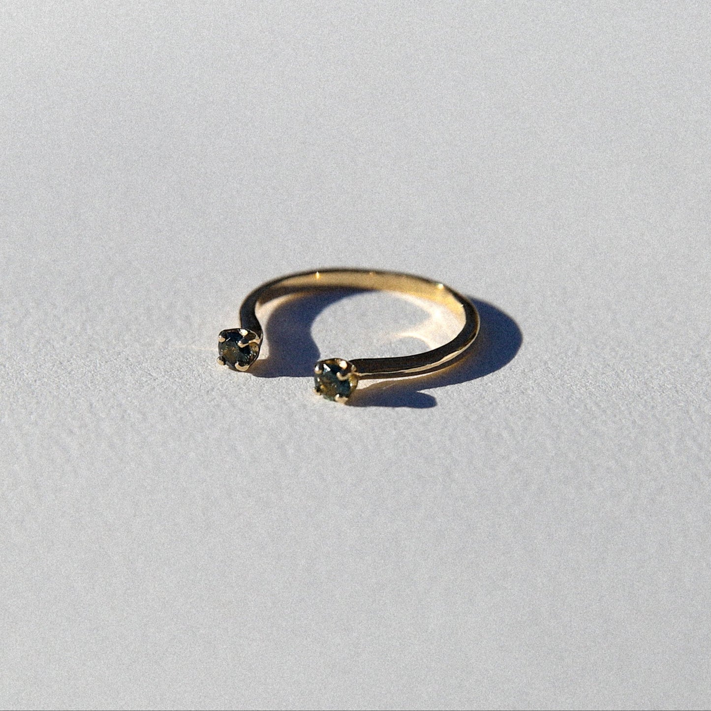 Gold ring with small gemstones on a light gray background