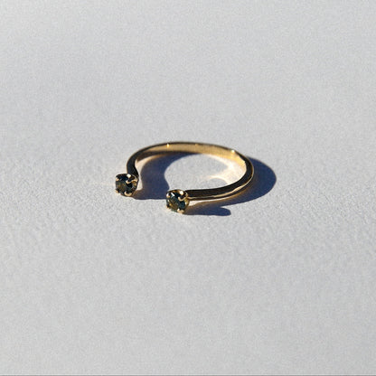 Gold ring with small gemstones on a light gray background