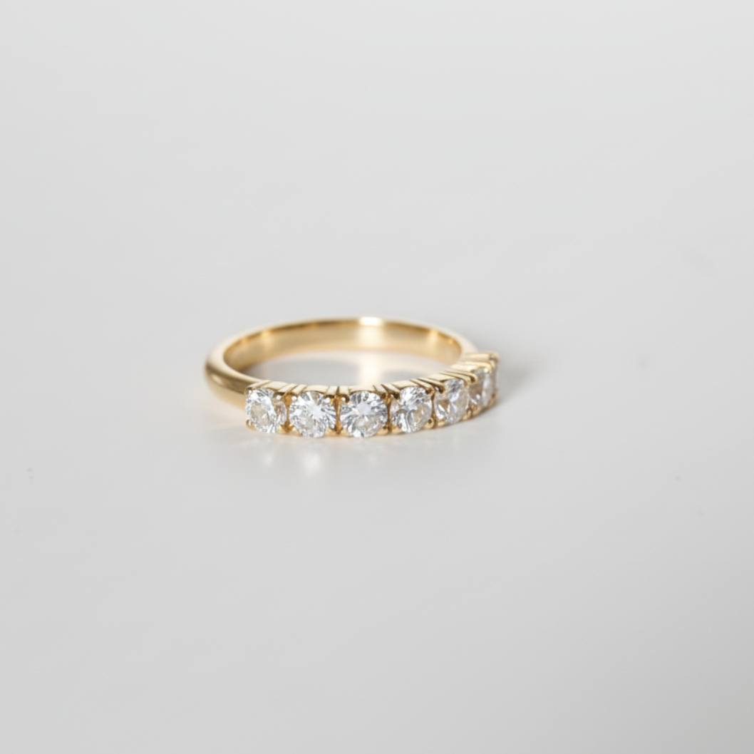 Gold ring with diamonds on a light gray background