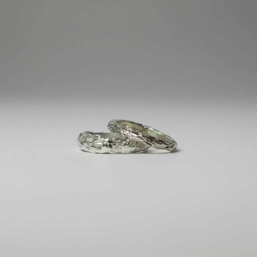 Two silver rings on a gray background