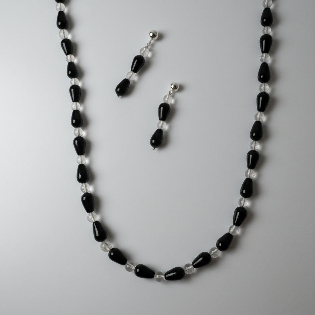 Black and white beaded necklace and earrings on a white background