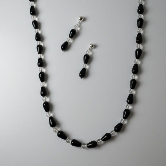 Black and white beaded necklace and earrings on a white background